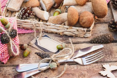 Çiğ beyaz mantar, çam kozalakları ve basit bir metin etiketi