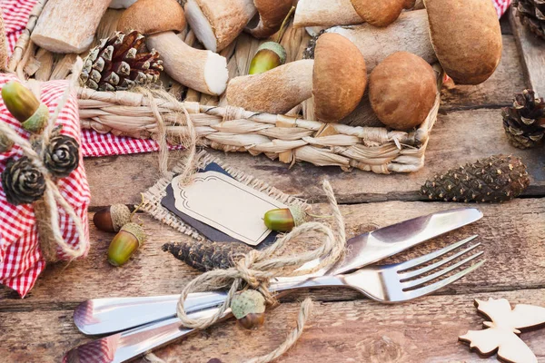 Çiğ beyaz mantar, çam kozalakları ve basit bir metin etiketi