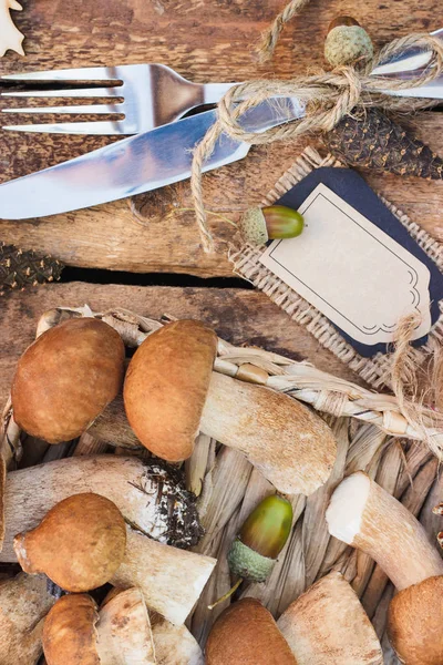 Çiğ beyaz mantar, çam kozalakları ve basit bir metin etiketi