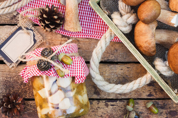 Raw white mushrooms, pine cones and decorative tag