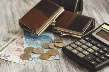 Küçük cüzdan ve ahşap arka plan üzerinde hesap makinesi ile Polonya Zlotisi