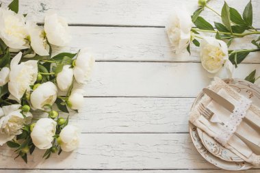 Sofra ve gümüş beyaz ahşap kurullarında beyaz peonies bir buket