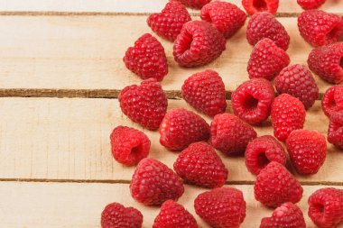 Hafif ahşap arka plan üzerinde kırmızı ahududu