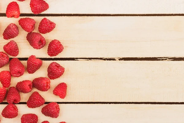 Hafif ahşap arka plan üzerinde kırmızı ahududu