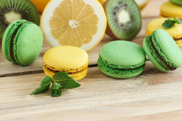 Yeşil ve sarı Fransız macarons kivi, limon ve nane süslemeleri ile