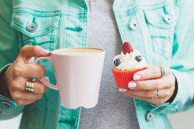 Bir fincan kahve ve çörek ile kadının el