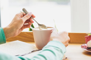 Bir fincan sıcak bir içecek ile kadının el