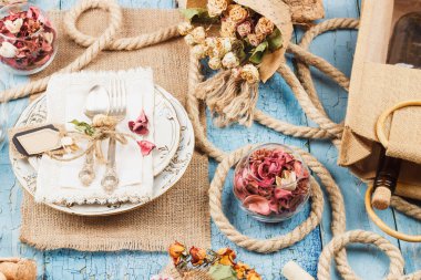 Sofra ve kuru çiçekler, yumuşak odak arka plan ile Gümüş eşyalar