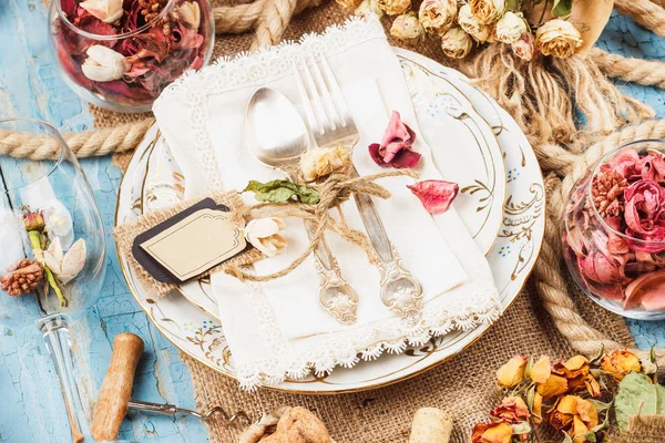 Tableware and silverware with dry flowers, soft focus background — Stock Photo, Image