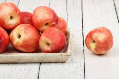 Olgun kırmızı şeftali içinde belgili tanımlık tepsi Beyaz ahşap tablo