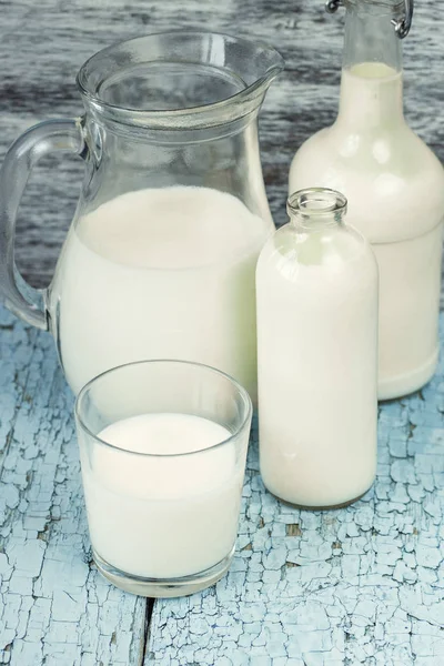 Jar and bottles with milk, and full glass with milk — Stock Photo, Image