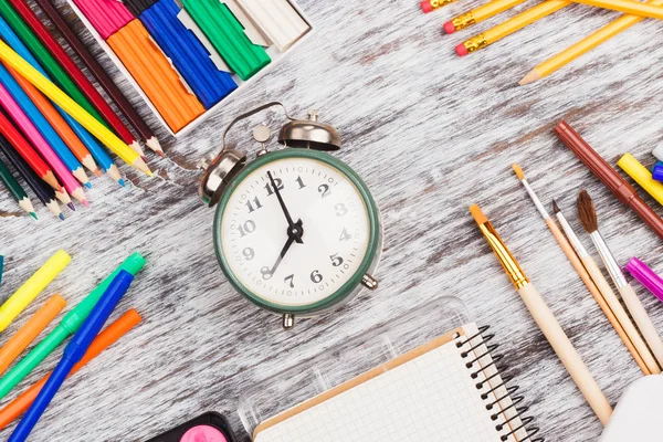 Diferentes materiais escolares: lápis, caderno, marcadores e conjunto de aquarelas, fundo de madeira — Fotografia de Stock