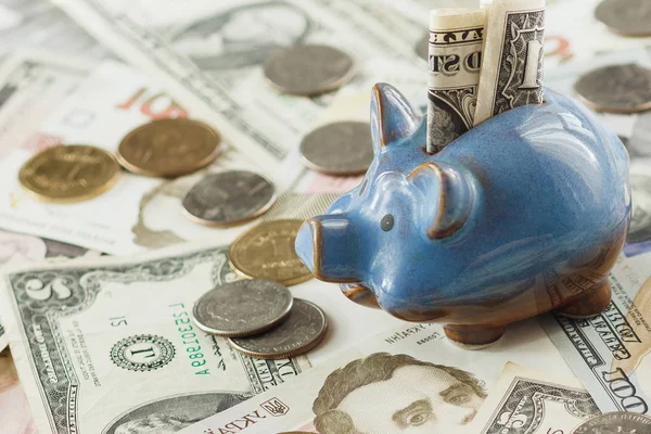 Ukrainian hryvnia and American's dollars with a piggy bank — Stock Photo, Image