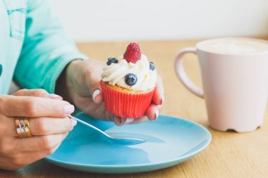Bir fincan kahve ve çörek plaka ile kadının el