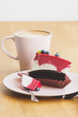 Fincan kapuçino ve tatlı plaka üzerinde bir parça