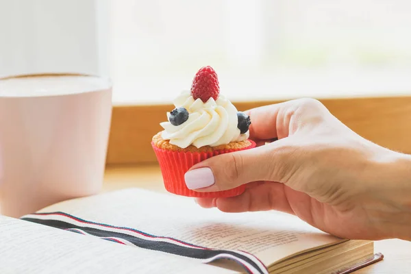 Main de femme avec un cupcake — Photo