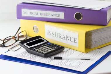 Temiz sigorta formu, klasörler, gözlük, hesap makinesi ve kalem