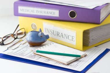 Temiz sigorta formu, klasör, kalem, kumbara ve gözlük