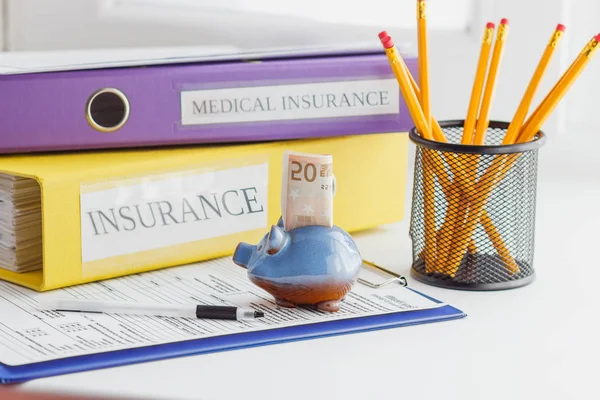 Fifty euro in the piggy bank and colored folders — Stock Photo, Image