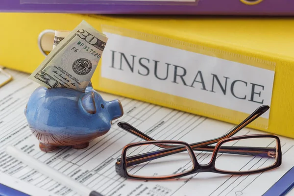 Clean insurance form, folders, pen, piggy bank and glasses — Stock Photo, Image