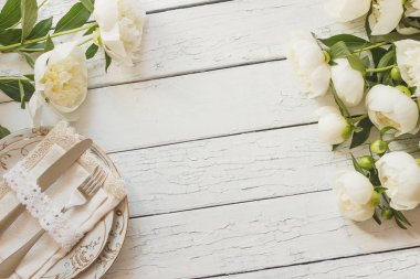Sofra ve gümüş beyaz ahşap kurullarında beyaz peonies bir buket