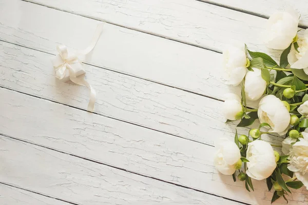 Beyaz peonies ve ahşap masa mevcut kutusunda buket