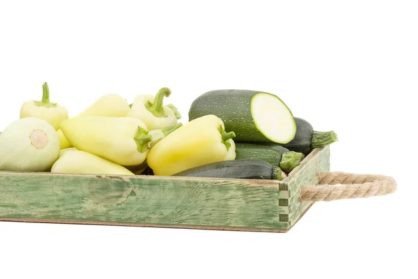 Πράσινο φρέσκο πιπεριές και κολοκυθάκια στο ξύλινο δίσκο, απομονωμένο — Φωτογραφία Αρχείου
