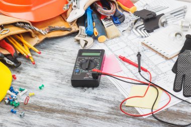 İnşaat araçları, çizimler ve multimetre, ahşap arka plan