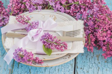 Sofra ve gümüş ile demet Menekşe leylak ahşap arka plan üzerinde