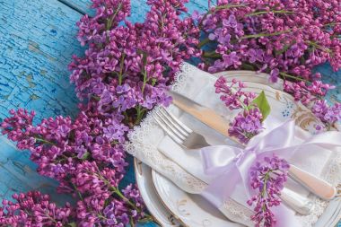 Sofra ve gümüş ile demet Menekşe leylak ahşap arka plan üzerinde