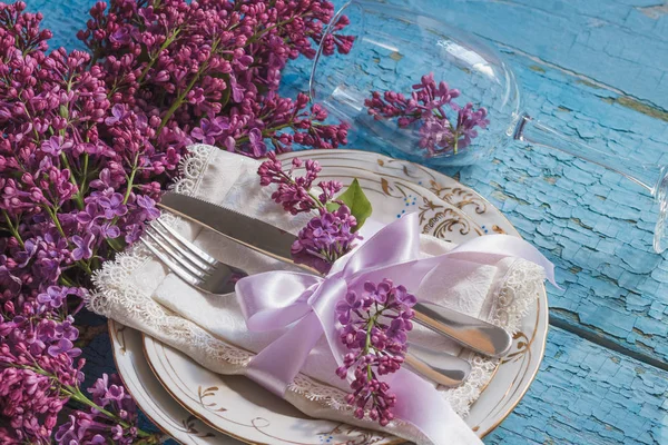 Sofra ve gümüş ile demet Menekşe leylak ahşap arka plan üzerinde