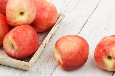 Olgun kırmızı şeftali içinde belgili tanımlık tepsi Beyaz ahşap tablo