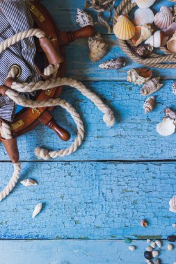 Çizgili çanta, tekerlek ve ahşap zemin üzerine deniz süslemeleri