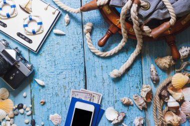 Çizgili çanta, tekerlek, telefon ve ahşap zemin üzerine deniz süslemeleri