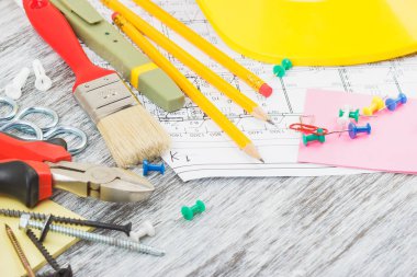 Çizimler, sarı kask ve farklı inşaat araçları