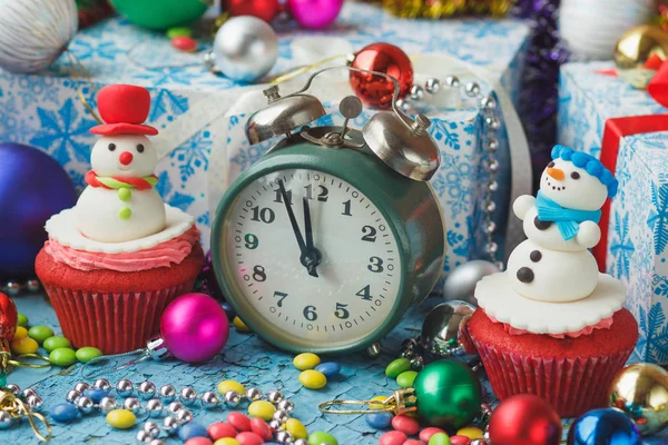 Green alarm clock and Christmas cupcakes with decorations made from confectionery mastic — Stock Photo, Image