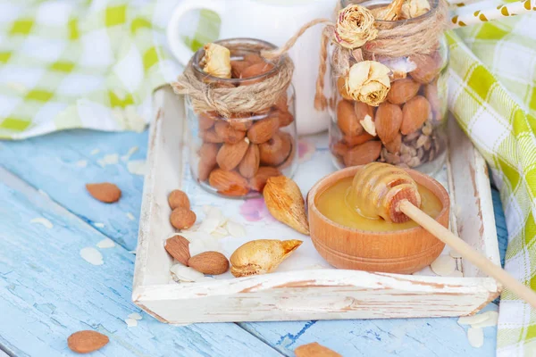 Honung i trä skålen, mandel och burk med mjölk i trä facket — Stockfoto