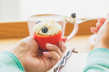 Ahududu ve yaban mersini, kitap ve fincan sıcak cappuccino küçük cupcake