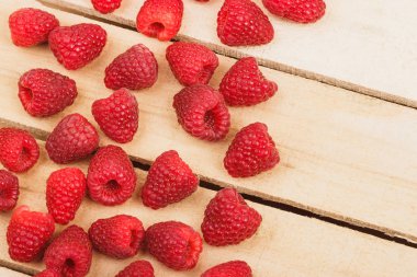 Hafif ahşap arka plan üzerinde kırmızı ahududu