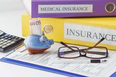 Temiz sigorta formu, klasör, kalem, piggy banka ve hesap makinesi