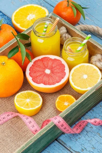 Diferentes frutas y vidrio con zumo de naranja fresco, fondo de madera —  Fotos de Stock