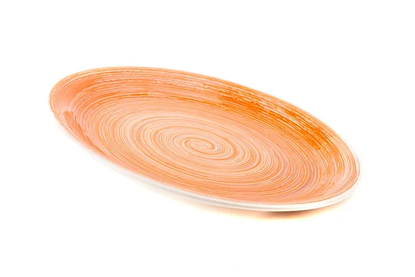 Помаранчева кругла керамічна тарілка з спіральним візерунком, ізольована на білому — стокове фото