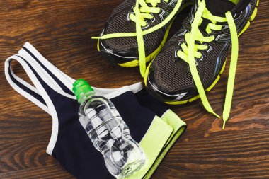 Spor öğeleri: spor ayakkabı, bir şişe su ve spor sütyen