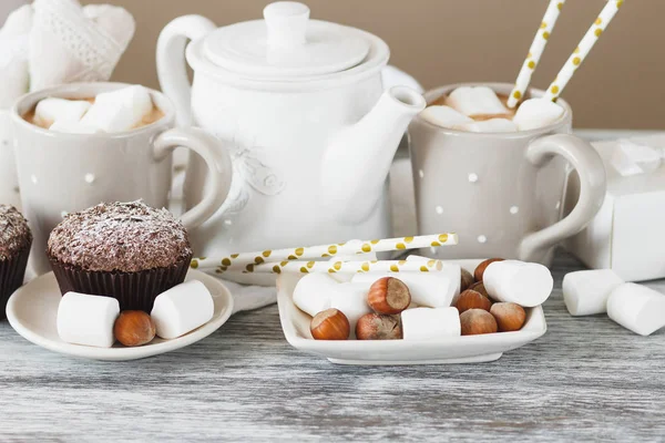 Tassen mit Kakao und Eibisch, Cupcakes und verschiedenen Dekorationen — Stockfoto