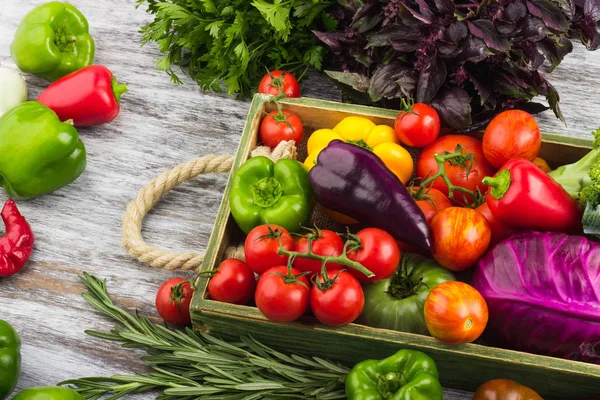 Colored vegetables in the wooden tray, light wooden background — Stock Photo, Image