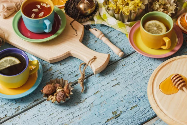 Κούπες με τσάι από βότανα και τα κομμάτια του λεμονιού, αποξηραμένα βότανα και διαφορετικές διακοσμήσεις — Φωτογραφία Αρχείου