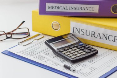 Temiz sigorta formu, klasör, kalem, gözlük ve hesap makinesi