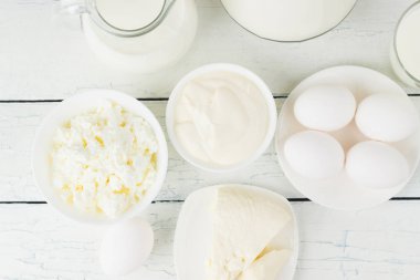 Beyaz ahşap zemin üzerinde farklı süt ürünleri