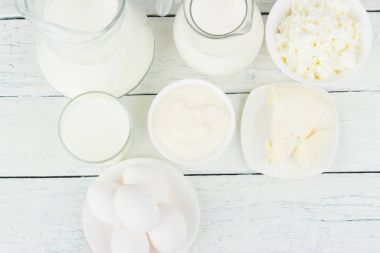 Beyaz ahşap zemin üzerinde farklı süt ürünleri