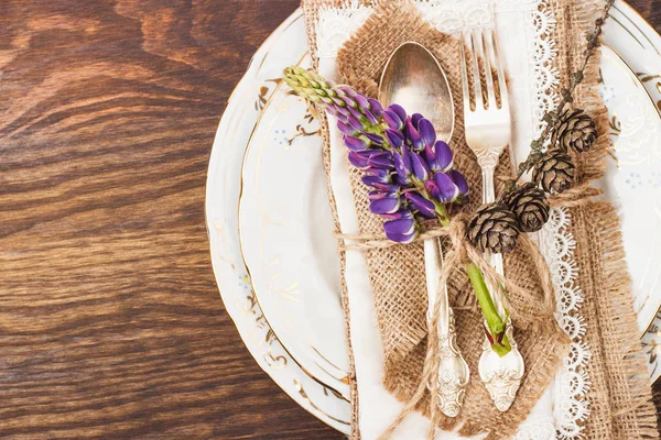 Tableware with violet lupines and silverware — Stock Photo, Image